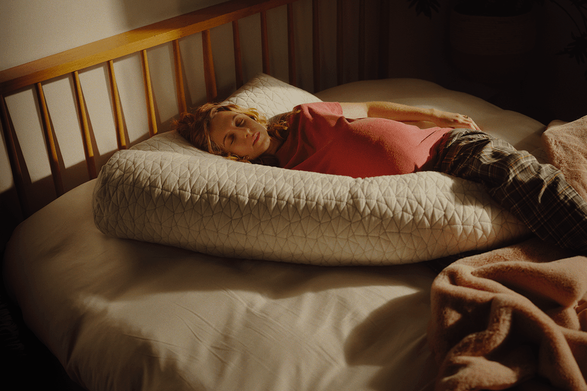 Pregnant woman sleeping on a maternity pillow