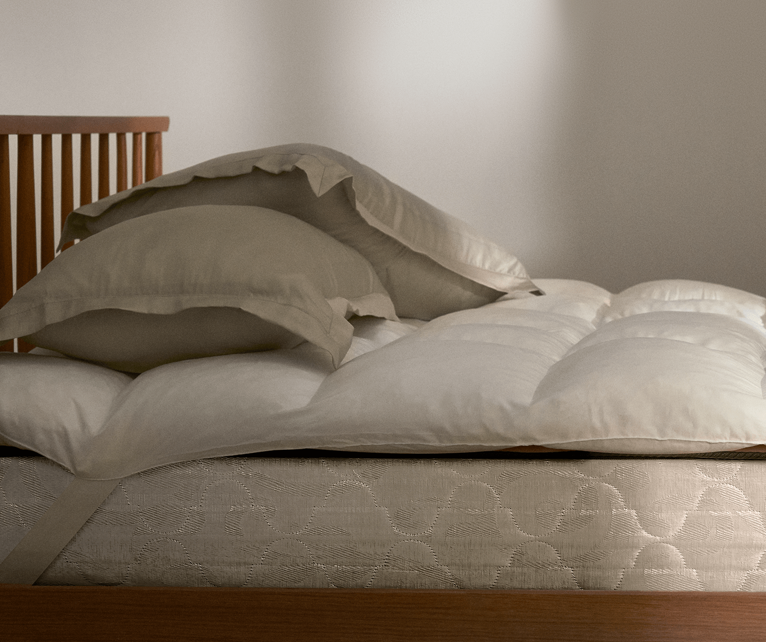 Mattress topper on bed with pillows stacked on top