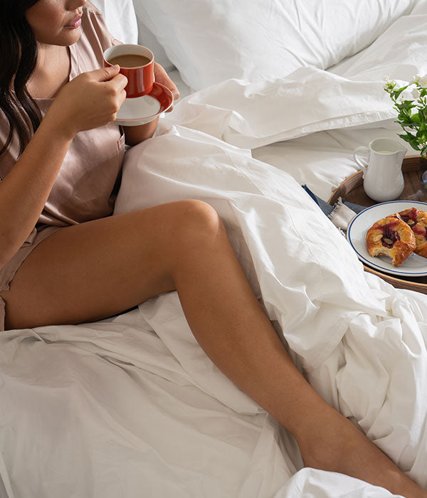 Woman relaxing in cotton percale sheets